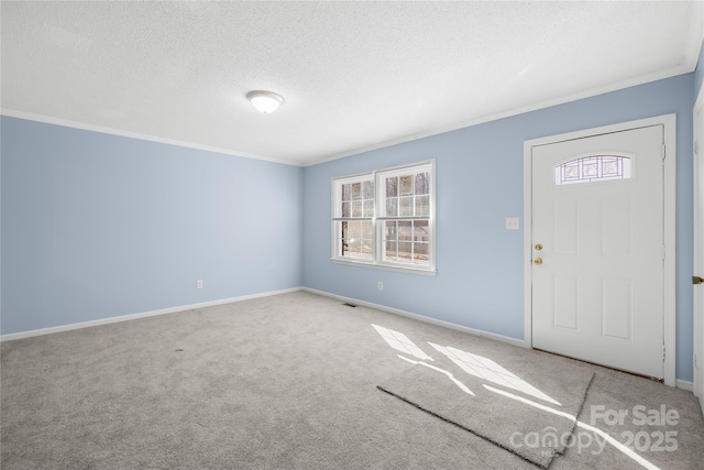 foyer with light carpet, ornamental molding, and a textured ceiling