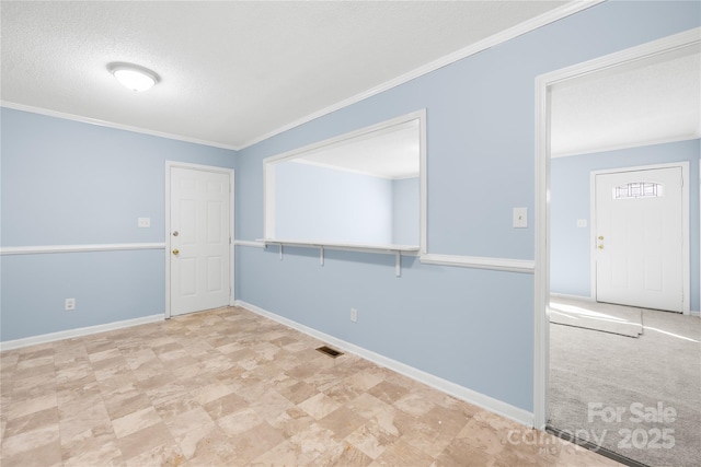 empty room featuring crown molding and a textured ceiling