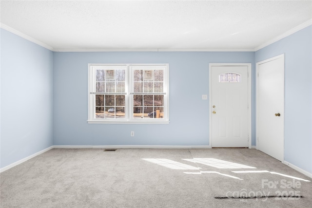 entryway featuring crown molding, carpet, and a textured ceiling