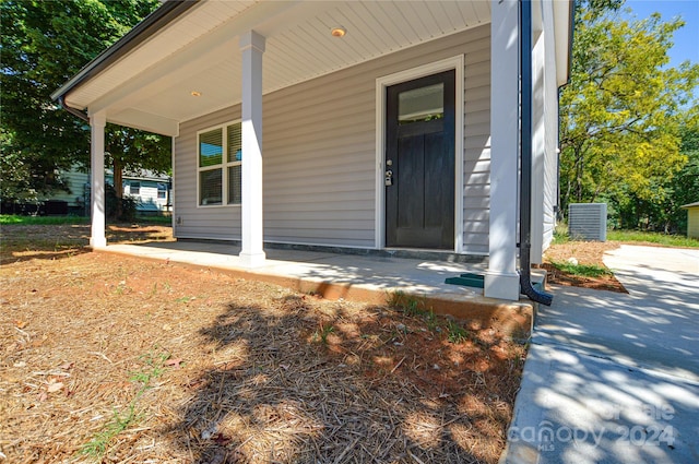 view of exterior entry featuring covered porch