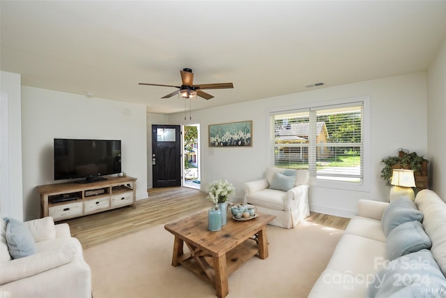 living room with light hardwood / wood-style flooring and ceiling fan