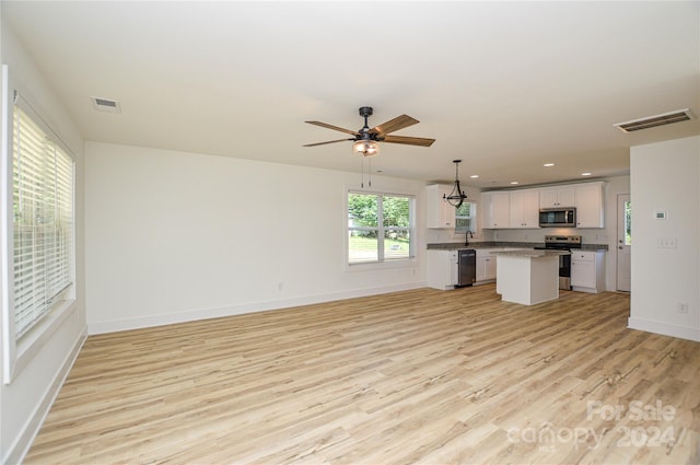 unfurnished living room featuring ceiling fan, light hardwood / wood-style flooring, and sink