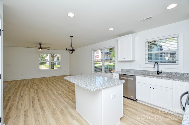 kitchen with white cabinets, dishwasher, light hardwood / wood-style floors, and sink