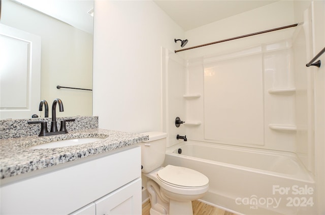 full bathroom featuring vanity, hardwood / wood-style floors, toilet, and washtub / shower combination