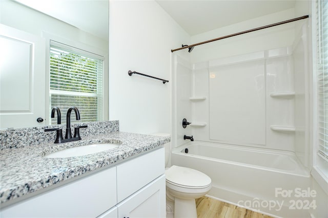 full bathroom featuring toilet, vanity, hardwood / wood-style floors, and  shower combination