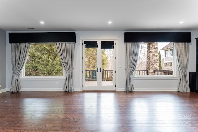 unfurnished room with dark wood-type flooring, a wealth of natural light, and french doors