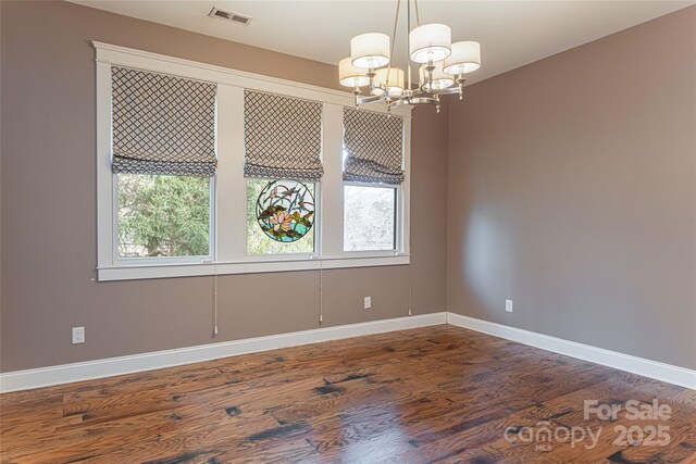 unfurnished dining area with a notable chandelier and dark hardwood / wood-style floors