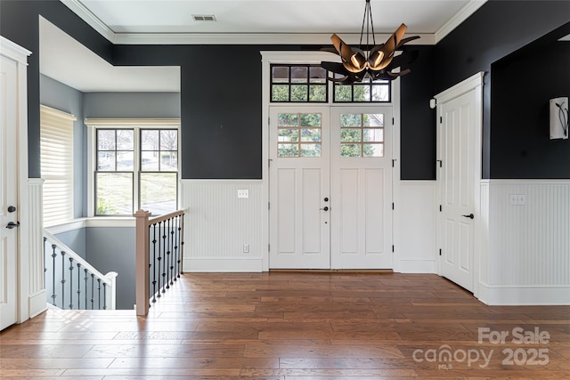 foyer with dark wood-type flooring and ornamental molding