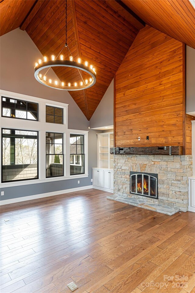 unfurnished living room with light hardwood / wood-style flooring, a fireplace, and high vaulted ceiling