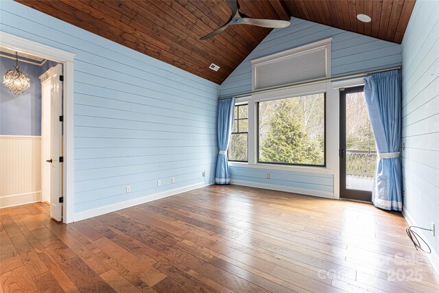 empty room with wood ceiling, wood-type flooring, and ceiling fan with notable chandelier