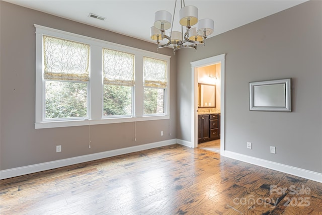 interior space featuring ensuite bath, light hardwood / wood-style flooring, and a chandelier