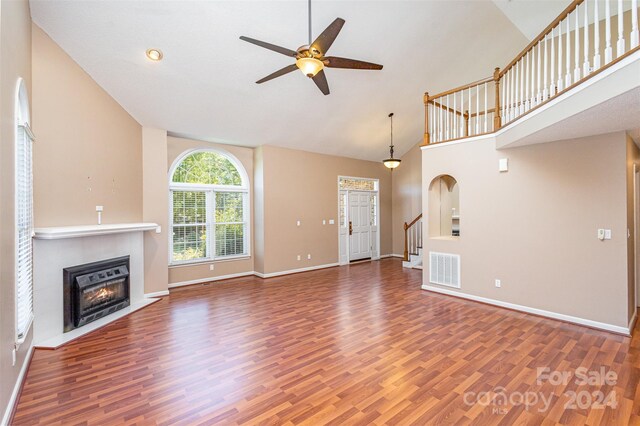 unfurnished living room featuring ceiling fan, dark wood-type flooring, and high vaulted ceiling