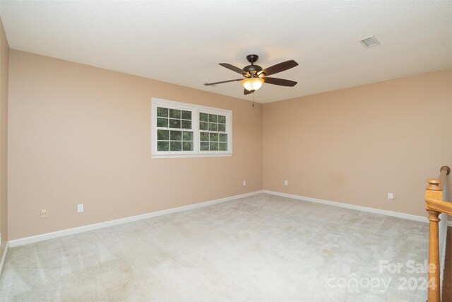 carpeted spare room featuring ceiling fan