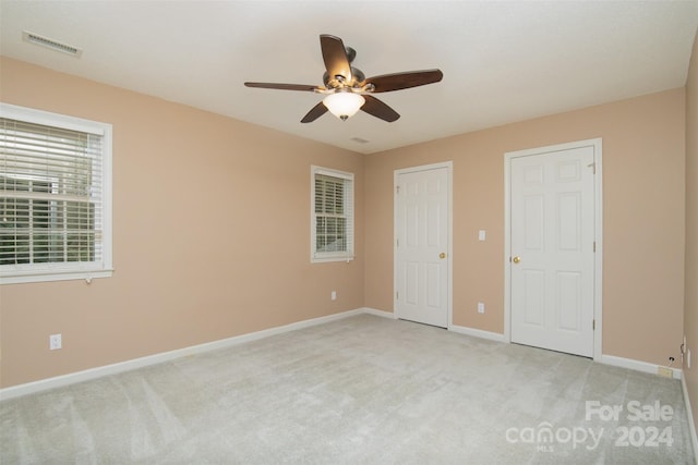 unfurnished bedroom with ceiling fan and light colored carpet