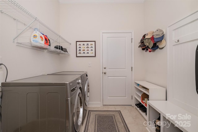 washroom with washing machine and dryer and light tile patterned floors