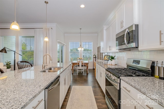 kitchen with light stone countertops, pendant lighting, white cabinets, appliances with stainless steel finishes, and tasteful backsplash