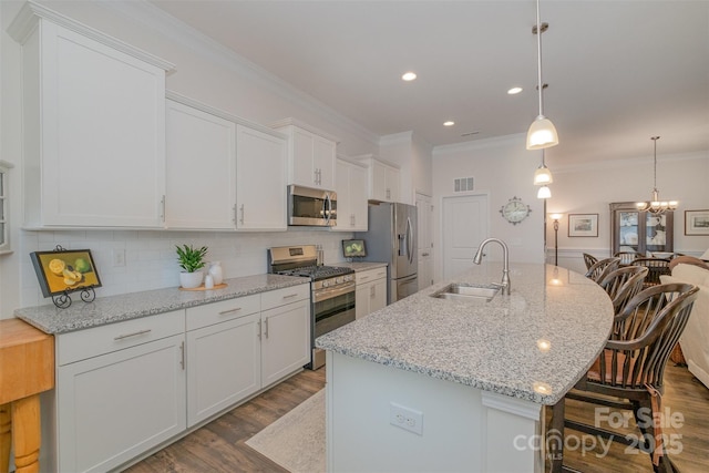 kitchen featuring sink, an island with sink, white cabinets, and appliances with stainless steel finishes