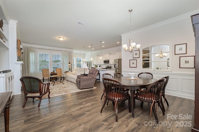 dining space featuring dark wood-type flooring, ornamental molding, and a chandelier