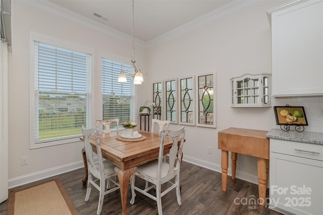 dining room with dark hardwood / wood-style floors and crown molding