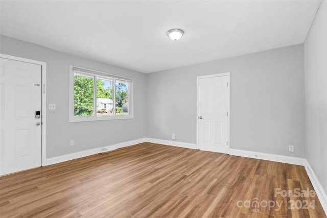 unfurnished room with visible vents, baseboards, and wood finished floors