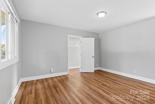 empty room with visible vents, baseboards, and wood finished floors