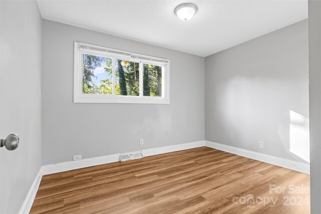 spare room with wood-type flooring