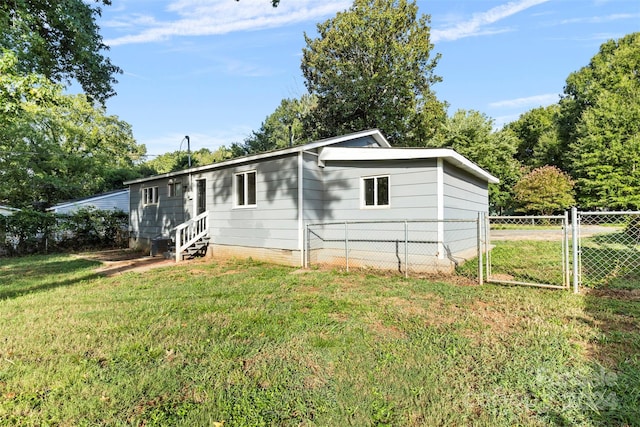 view of front facade featuring entry steps, fence, a front lawn, and a gate