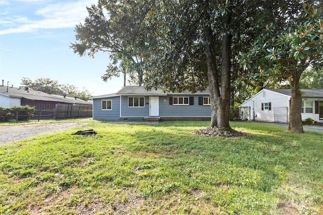 view of front of house featuring entry steps, a front yard, and fence