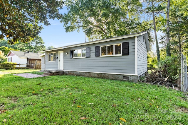 view of front of house with crawl space, a front lawn, and fence