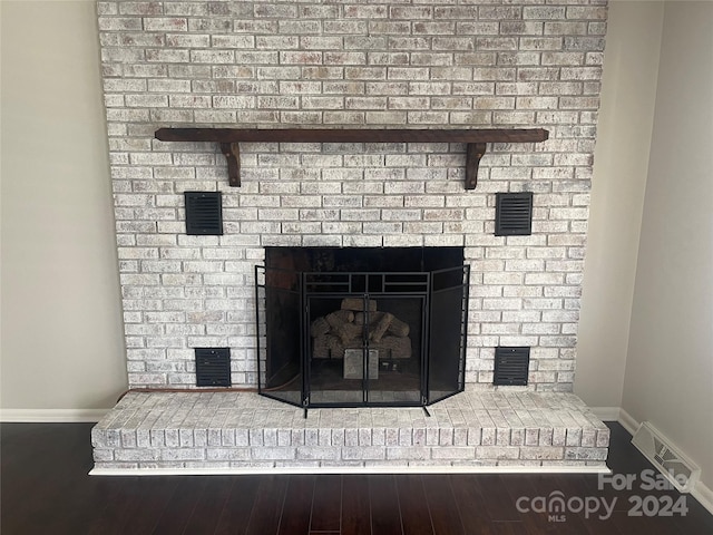 interior details featuring hardwood / wood-style floors and a brick fireplace