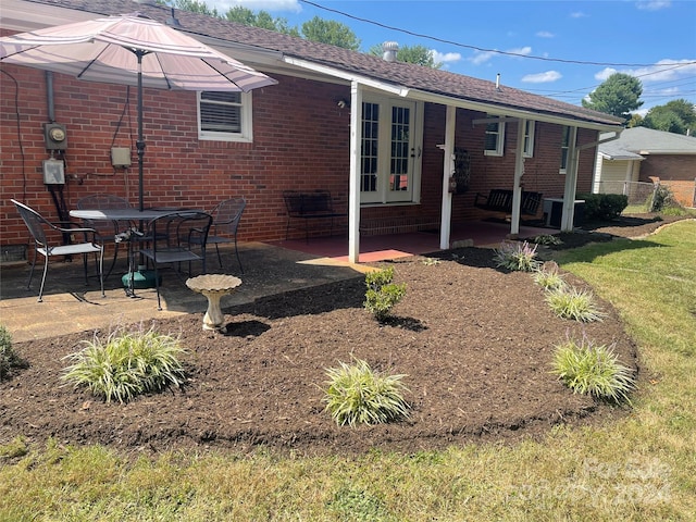 back of property with a lawn and a patio