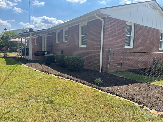 view of property exterior with a lawn and central AC unit