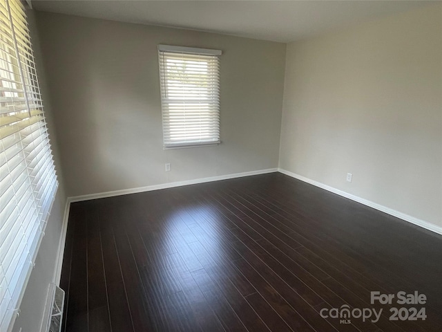 spare room featuring dark wood-type flooring