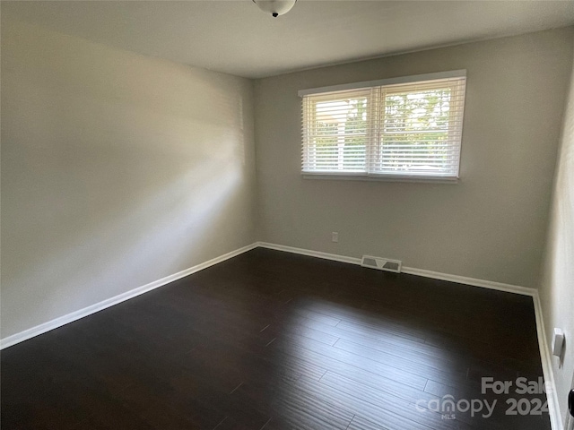 empty room featuring dark hardwood / wood-style flooring