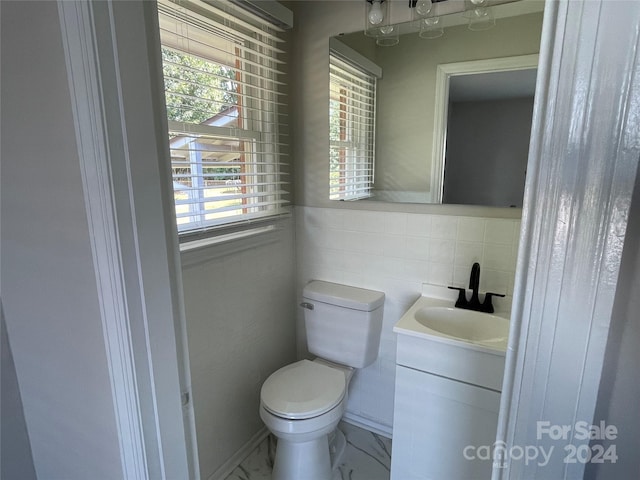 bathroom with tile walls, toilet, tasteful backsplash, and vanity