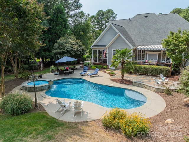 view of swimming pool with a sunroom, a patio area, and an in ground hot tub