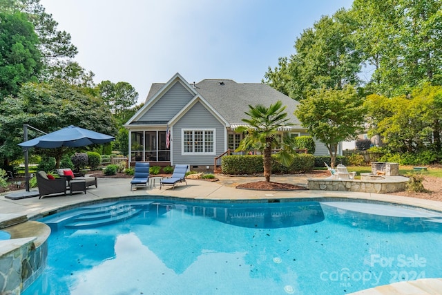 view of swimming pool featuring a patio area and a sunroom