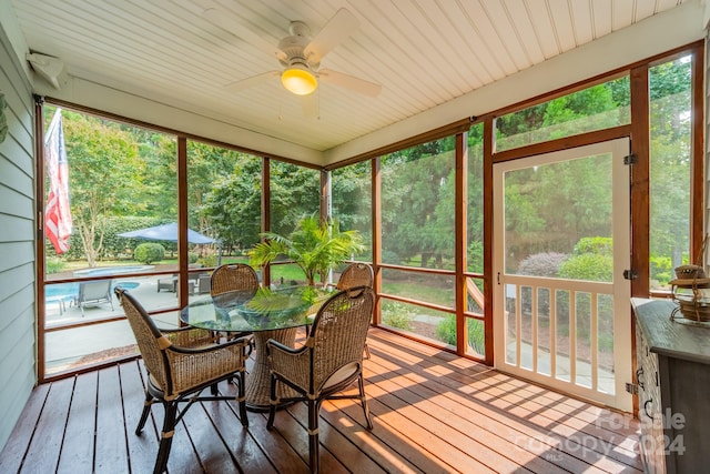 sunroom with ceiling fan and wood ceiling