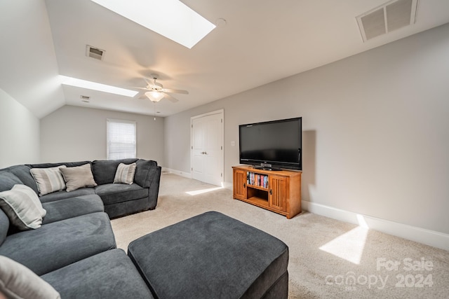 carpeted living room featuring ceiling fan and vaulted ceiling with skylight