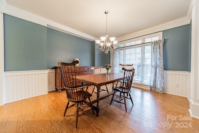 dining area with a chandelier, light hardwood / wood-style floors, and crown molding