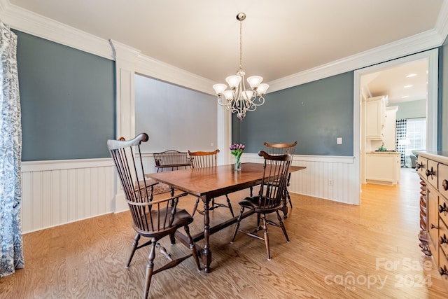 dining room featuring an inviting chandelier, light hardwood / wood-style floors, and ornamental molding