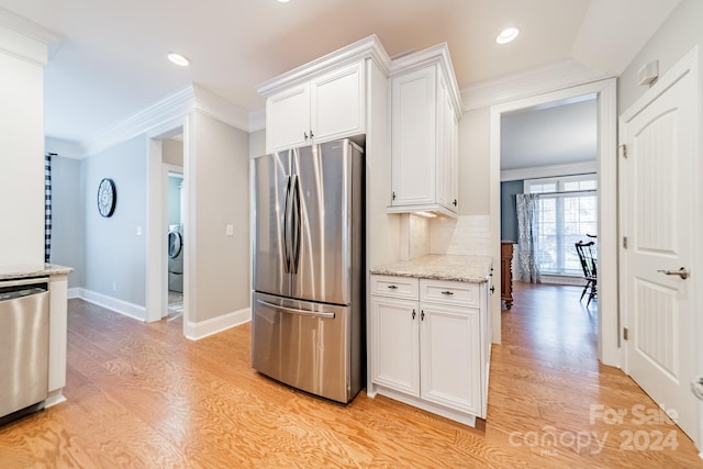 kitchen with washer / clothes dryer, white cabinetry, light wood-type flooring, and appliances with stainless steel finishes