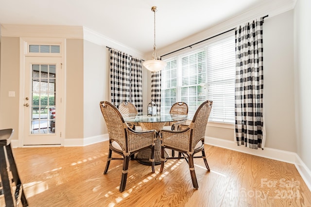 dining area with light wood-type flooring and crown molding