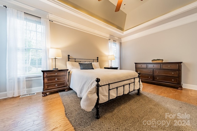 bedroom with light hardwood / wood-style flooring, multiple windows, crown molding, and ceiling fan