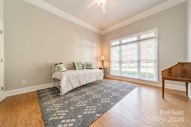 bedroom featuring hardwood / wood-style flooring, ceiling fan, and crown molding