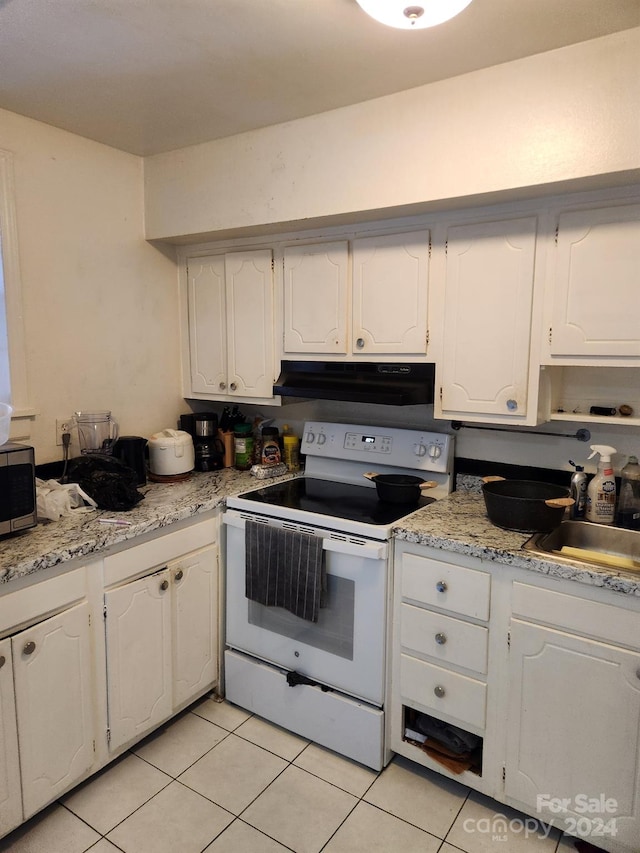 kitchen featuring electric stove, white cabinetry, and light tile patterned flooring