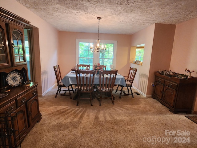 dining area with baseboards, light carpet, a textured ceiling, and a chandelier