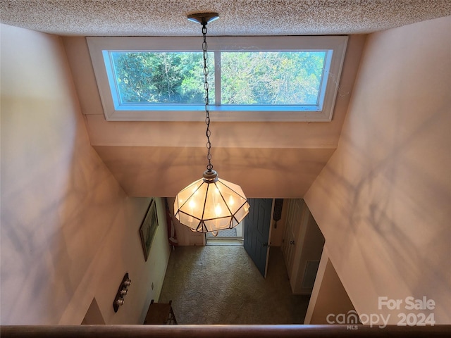 details with a textured ceiling and an inviting chandelier