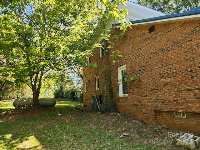 view of property exterior featuring crawl space, a yard, and brick siding