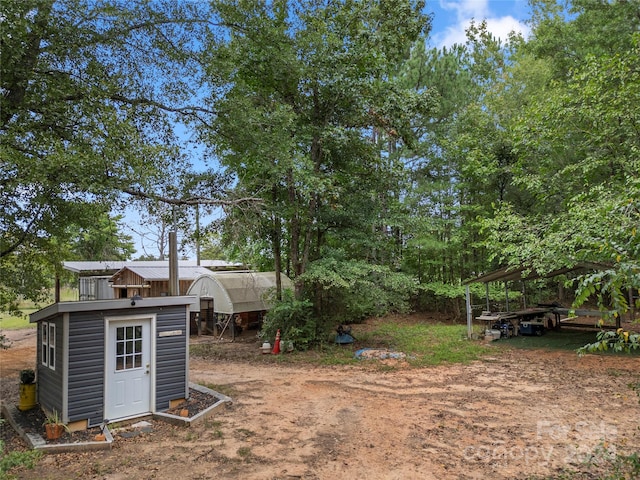 view of yard featuring a carport and a shed